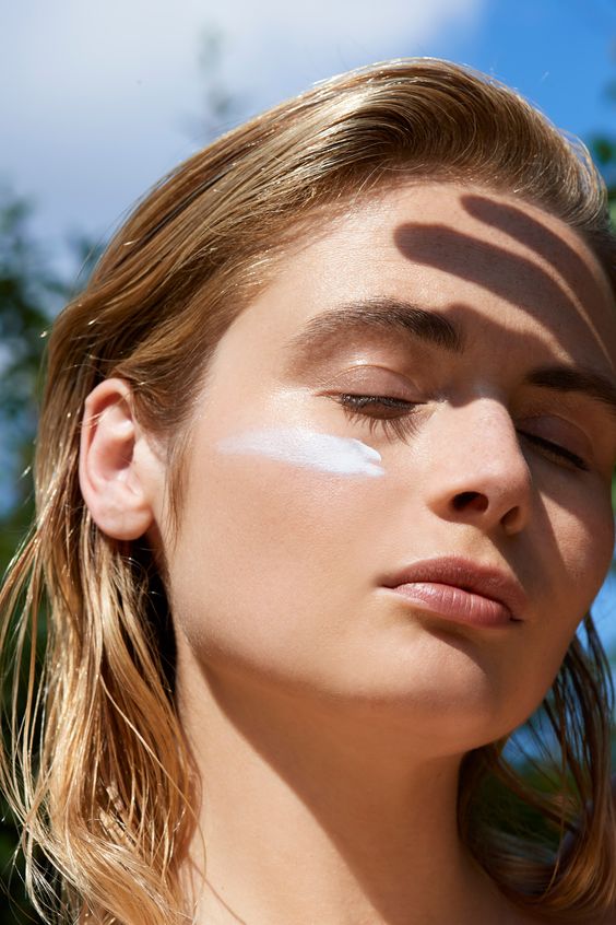 صورت زن و استفاده از کرم ضد آفتاب